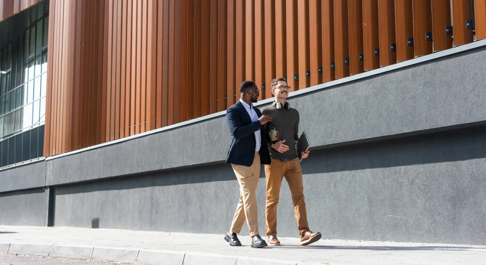 Colleagues walking outside modern building