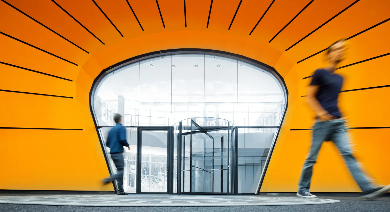 People walking by modern architecture 