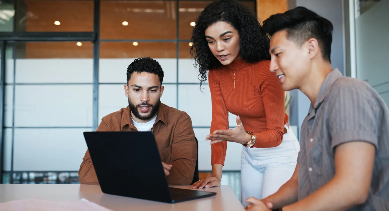 Three people looking at a laptop