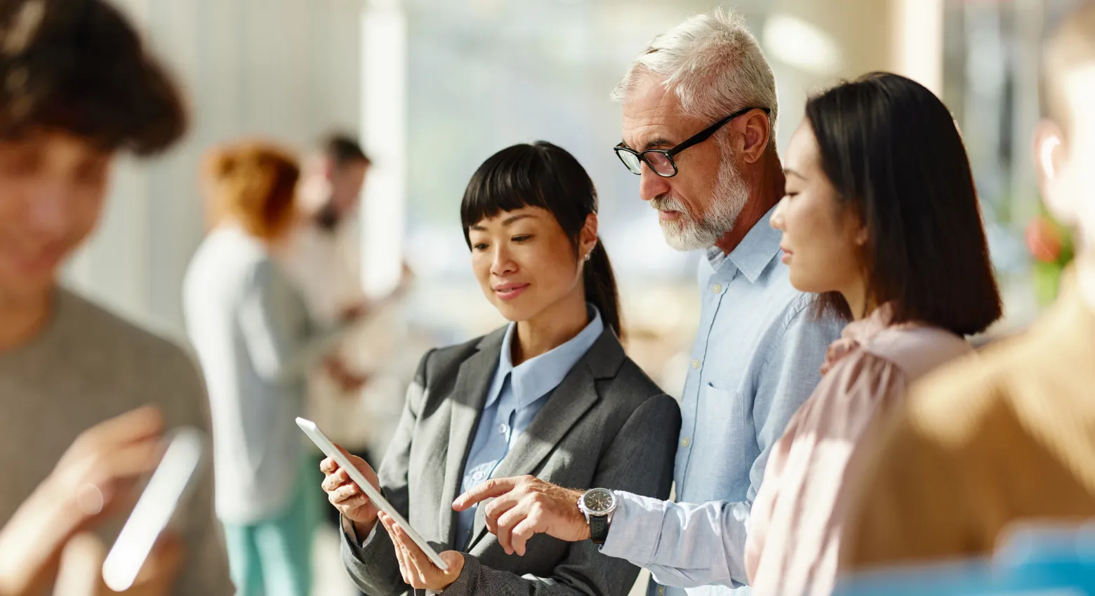 Three people looking at a tablet