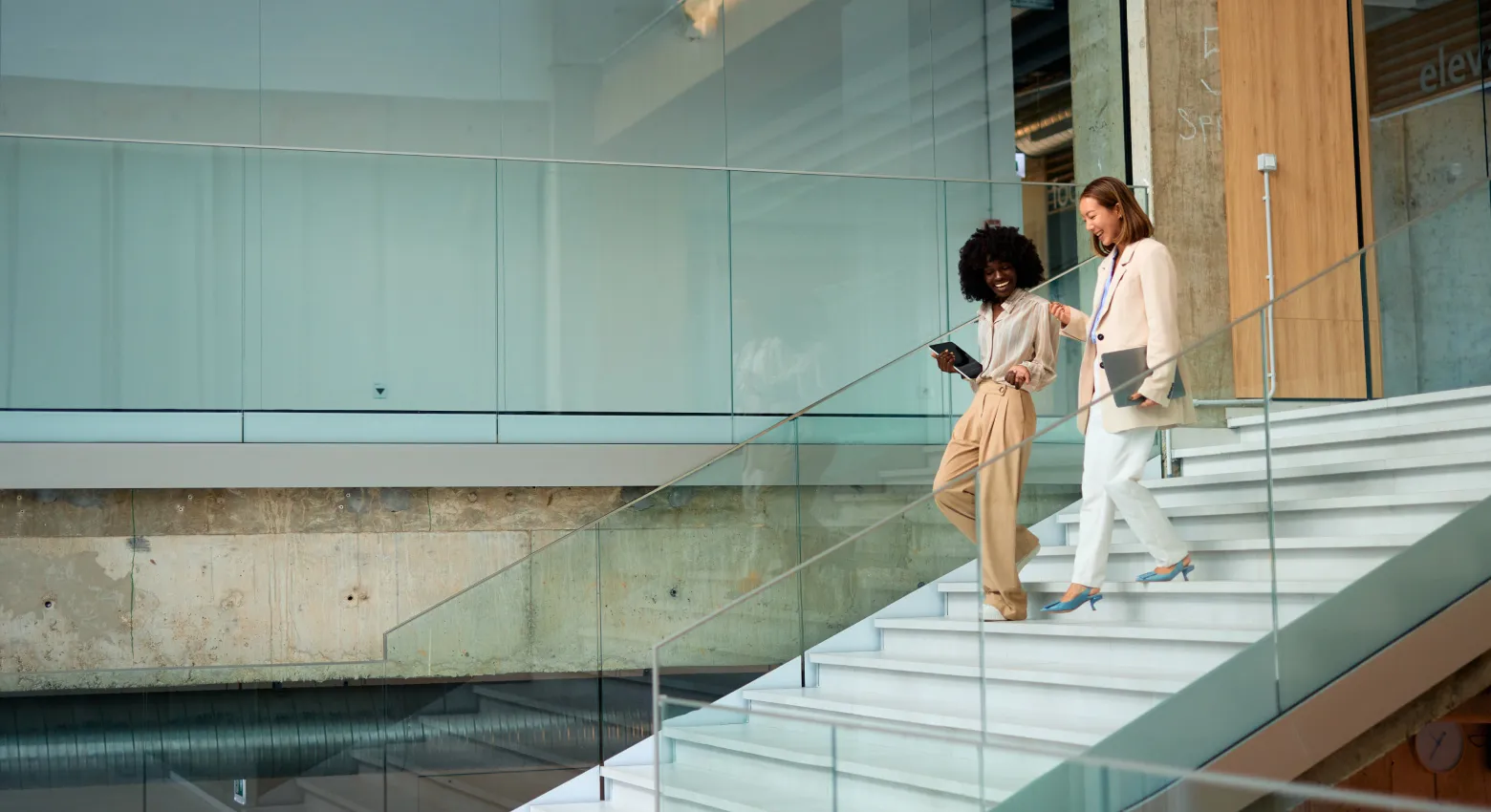 Two women walking and talking in modern building 