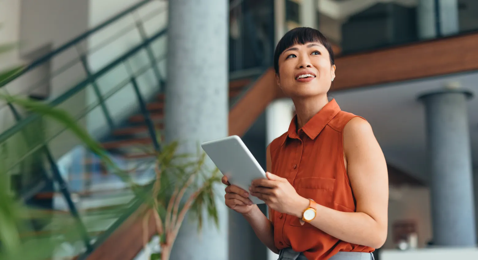 Woman with tablet looking up
