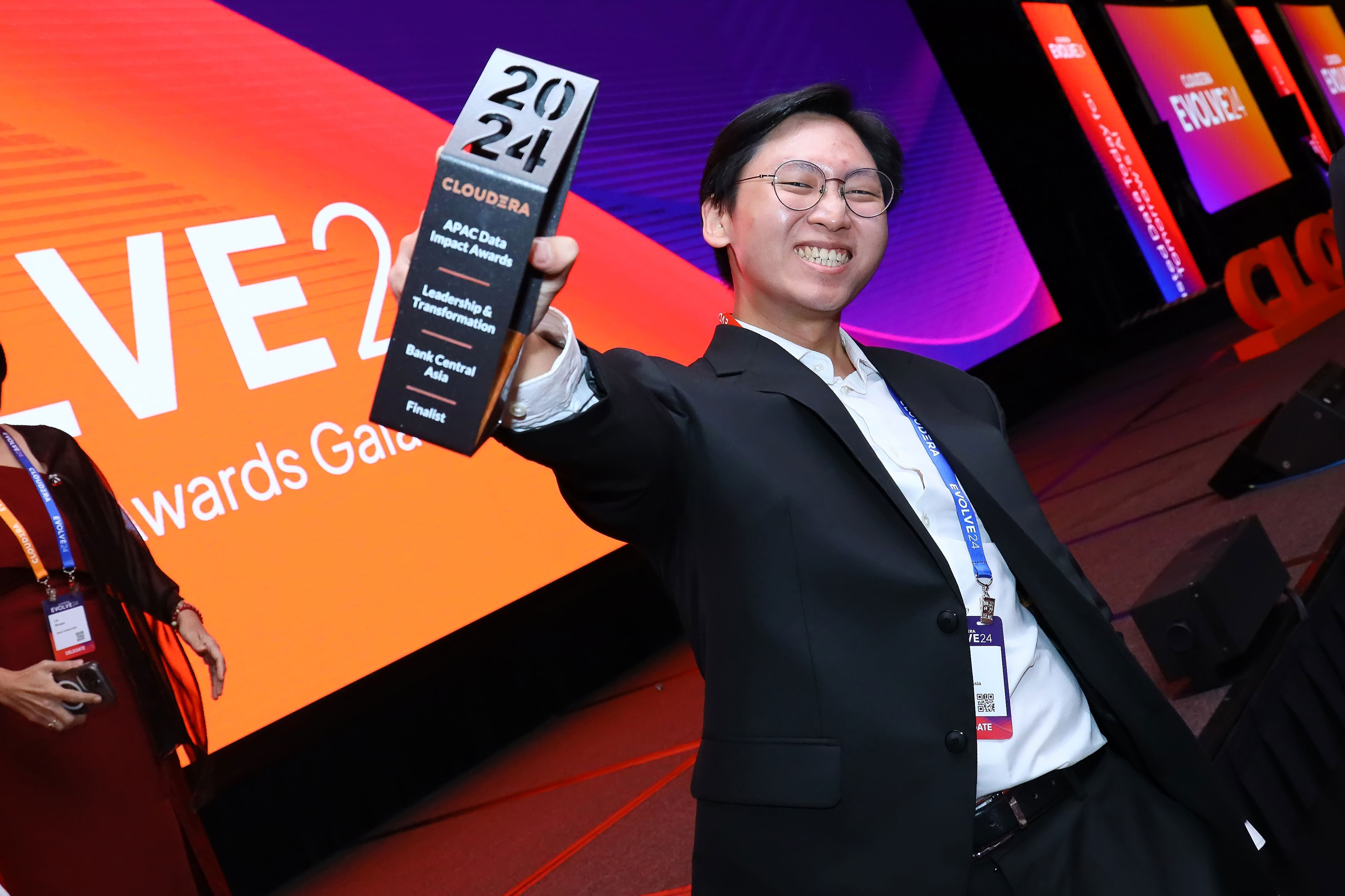 Man holding up his Data Impact Award and smiling