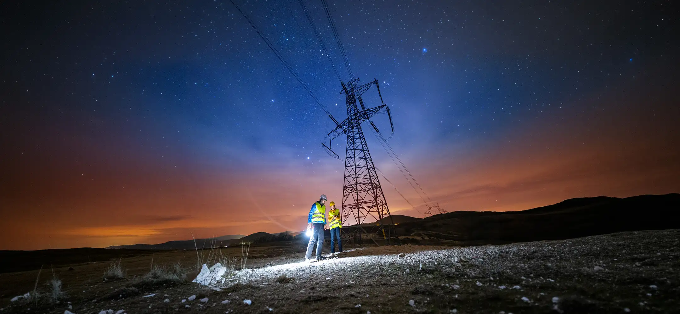 Workers on top of a wind turbine looking out.