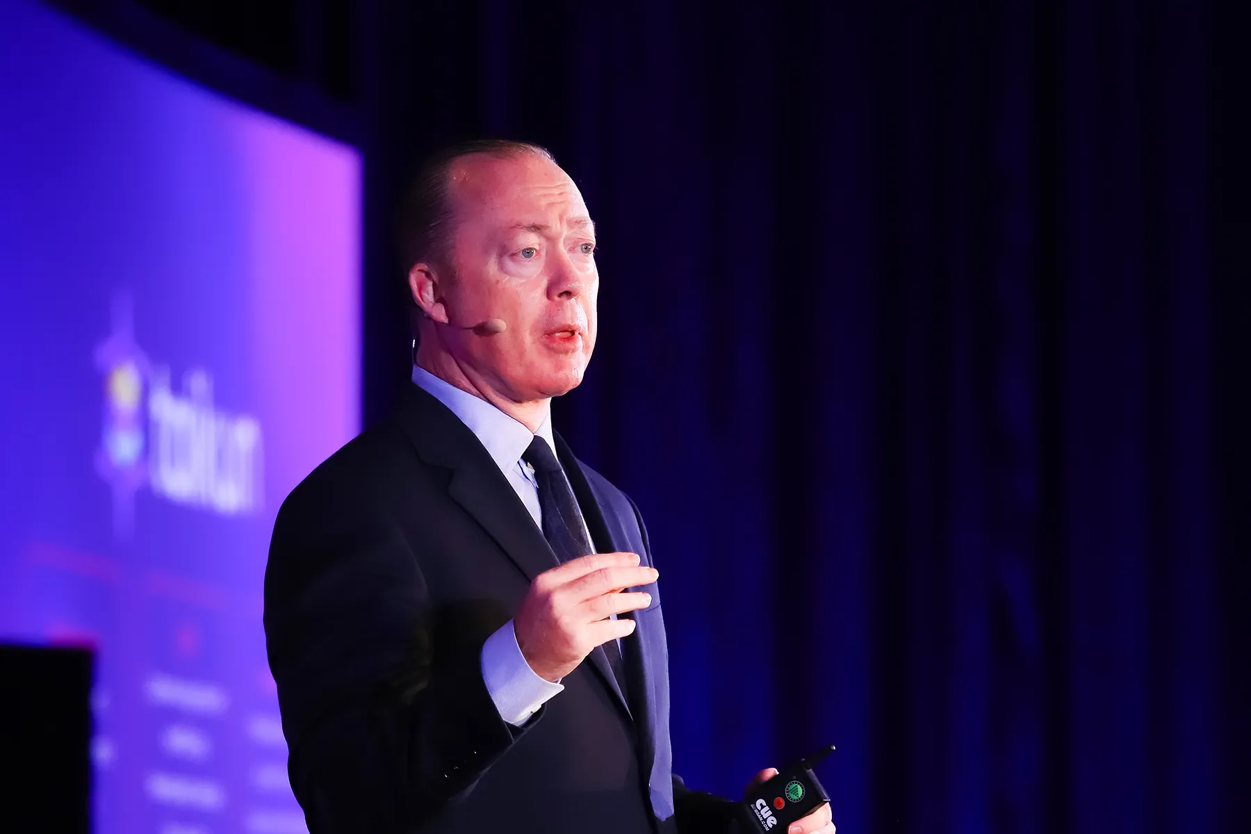 A woman and a man speaking about customer successes on stage