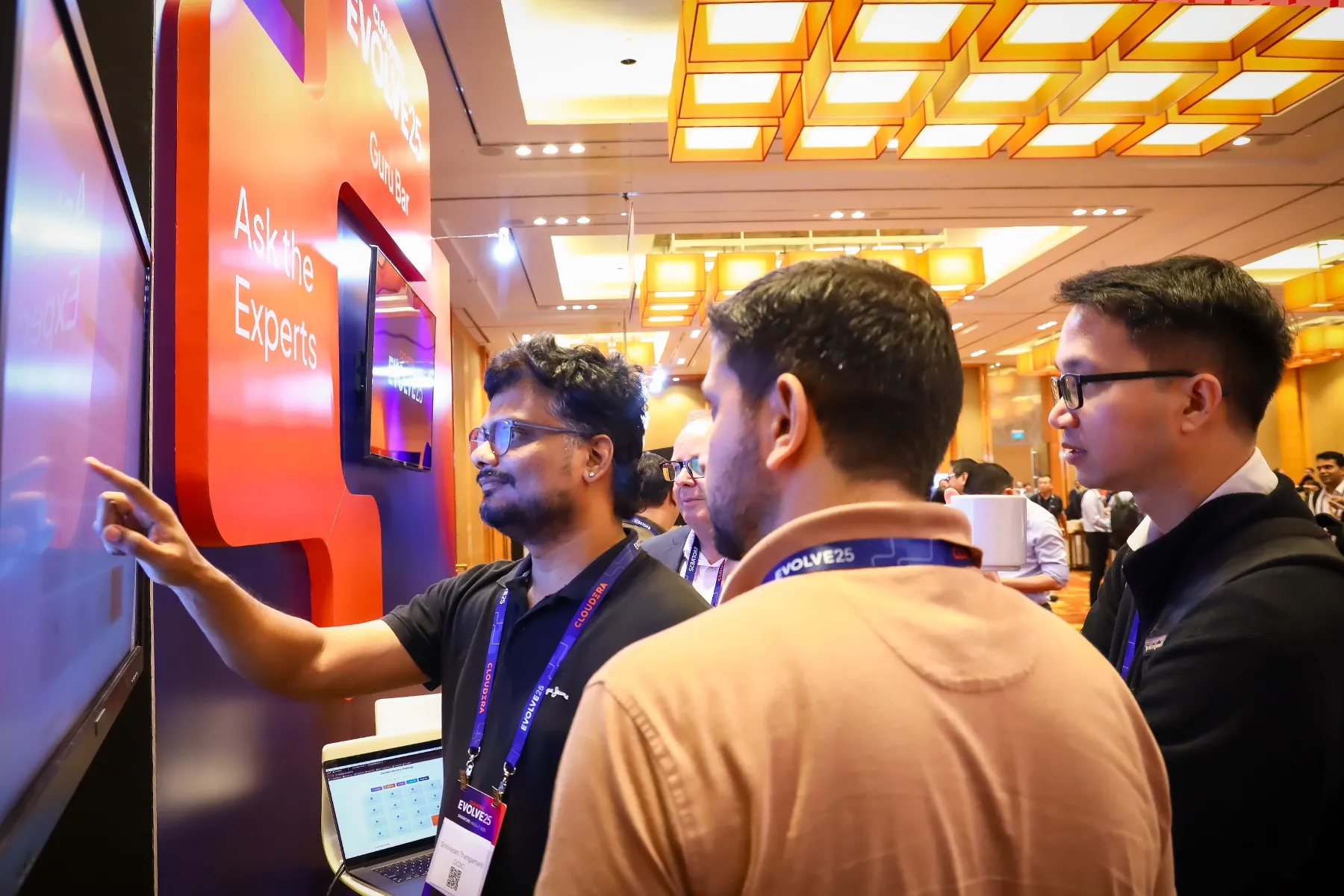 Attendees watch a demo at the an EVOLVE booth. 