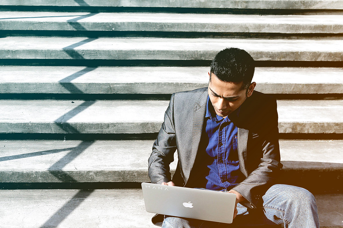 Man on steps with laptop